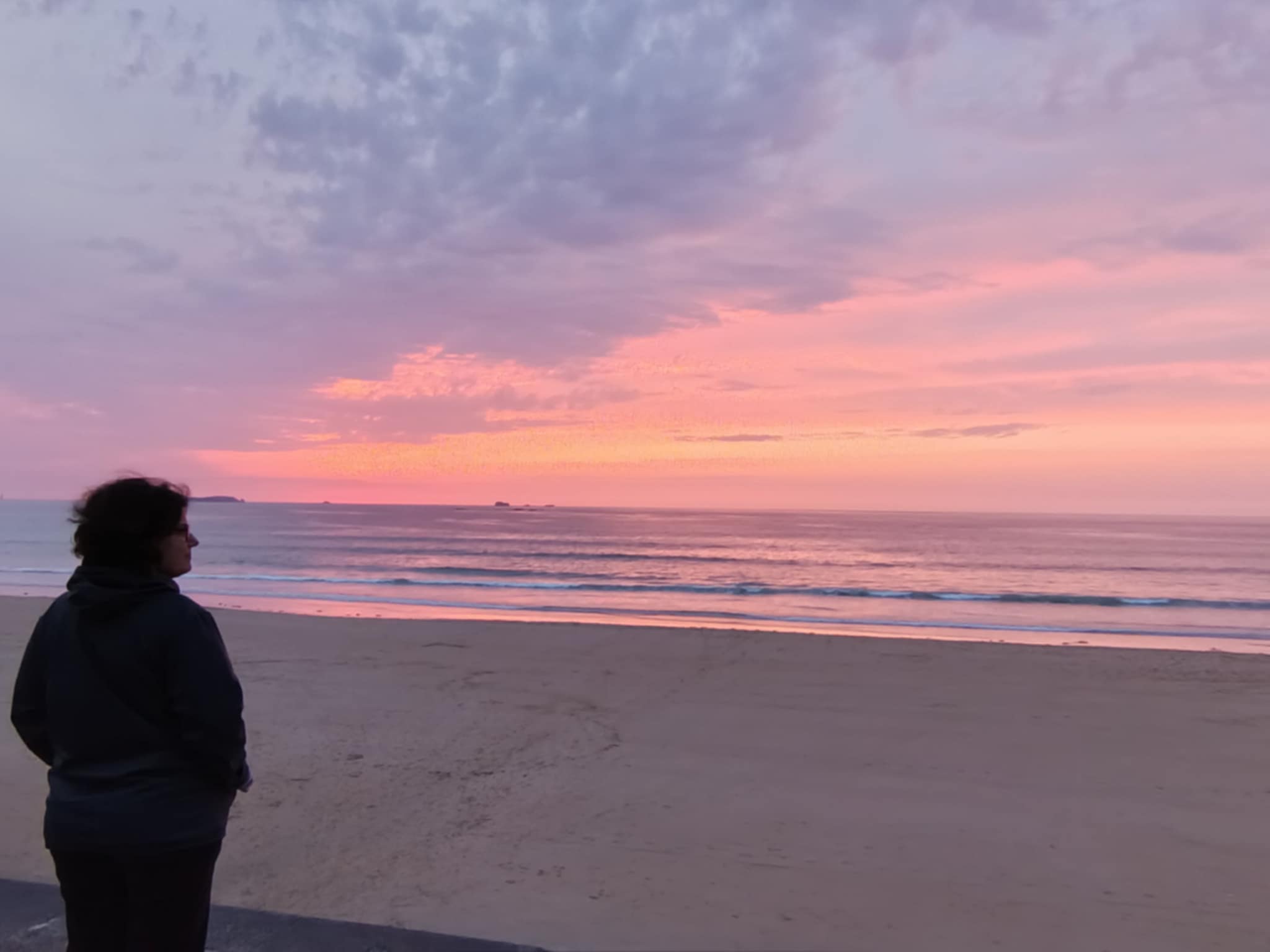 Silhouette de femme qui regarde le coucher de soleil sur la mer