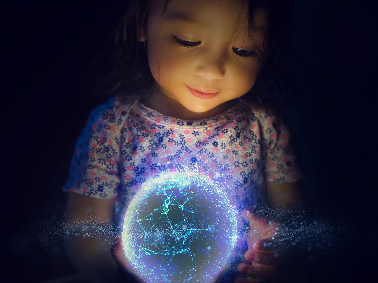 Petite fille qui tient une sphère lumineuse entre ses mains