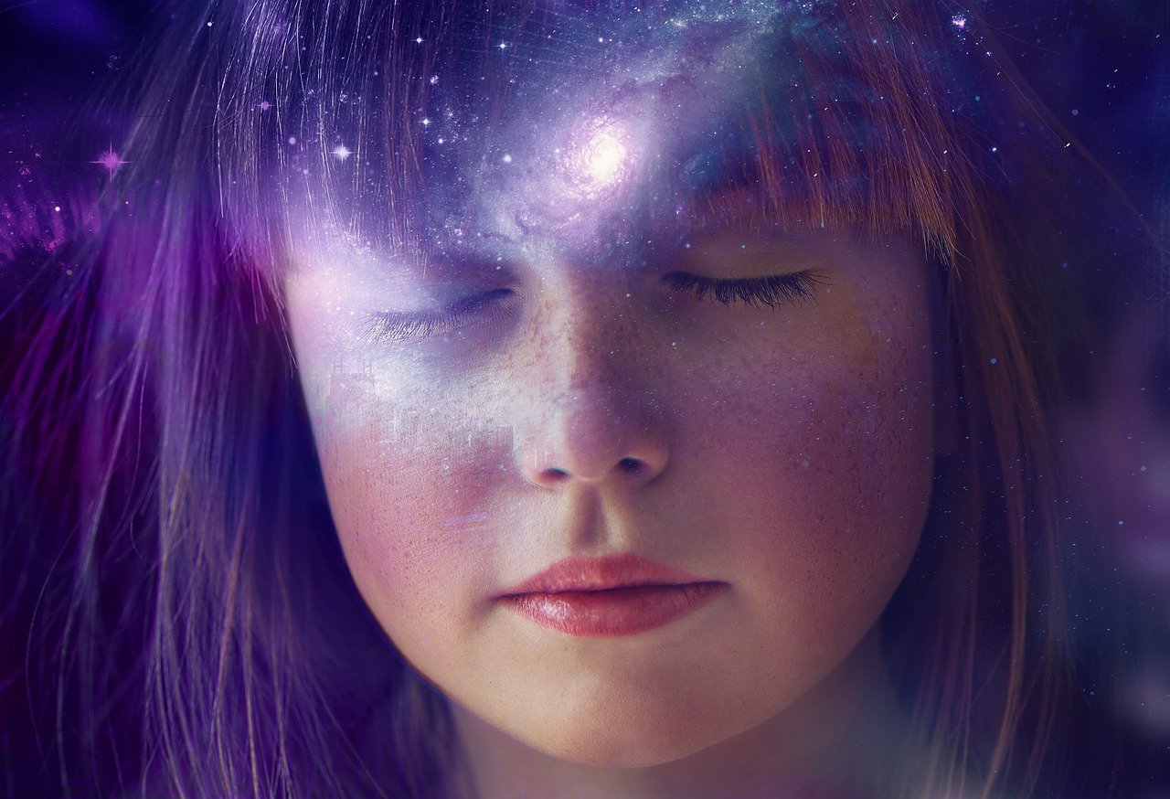 Fille les yeux fermés avec l'univers dans sa tête